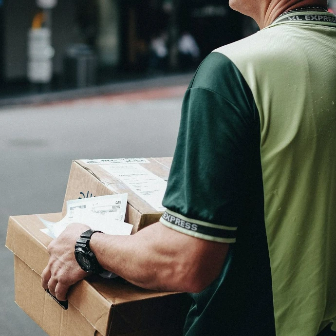man carrying cardboard boxes during daytime