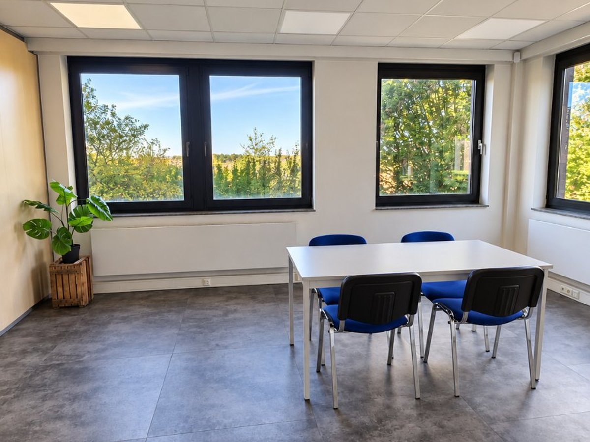 Petite salle de réunion lumineuse d'Unita Business Zaventem, Romboutsstraat 7, avec table blanche et quatre chaises